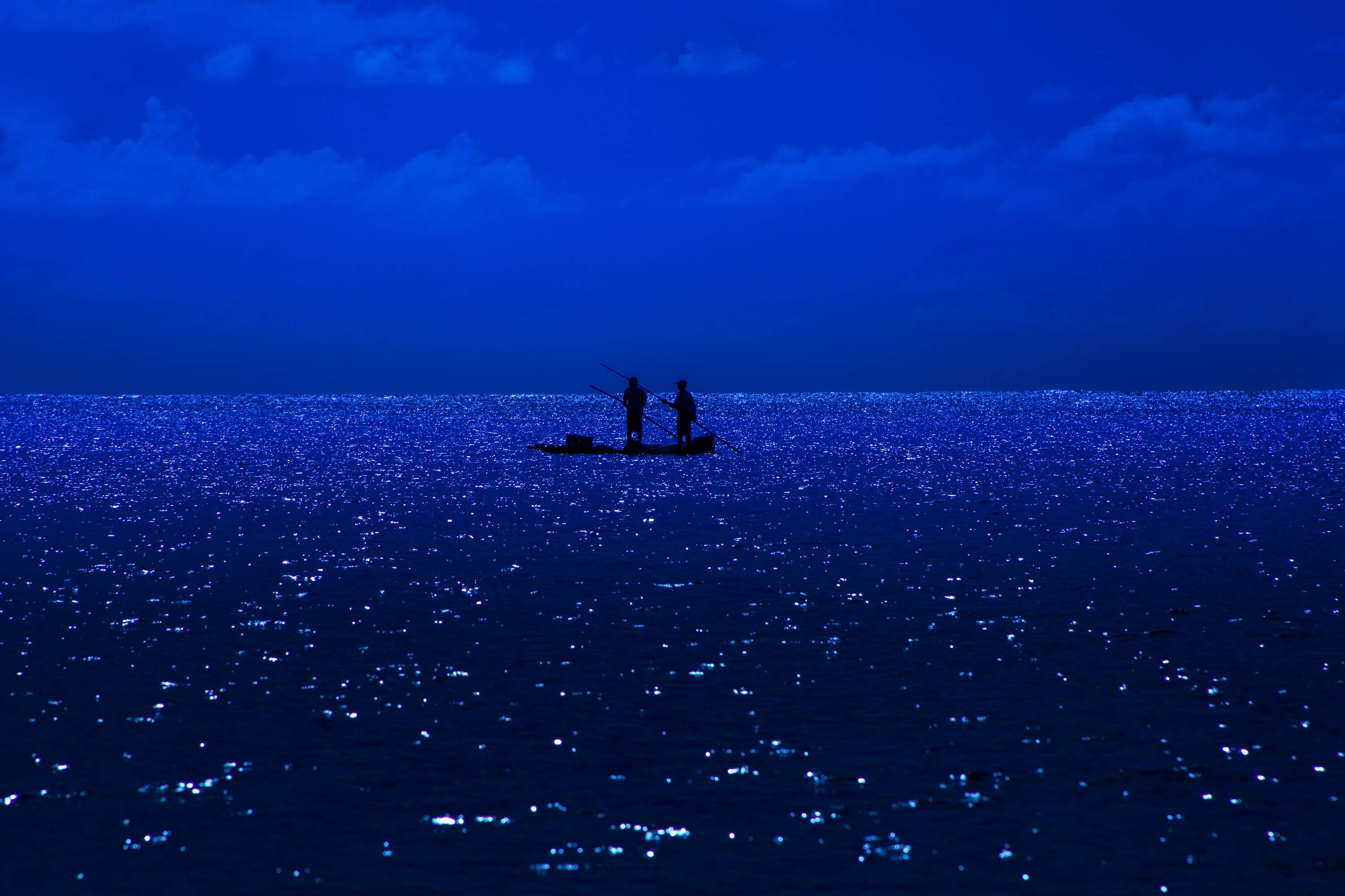 Pescadores em jangada no mar à noite